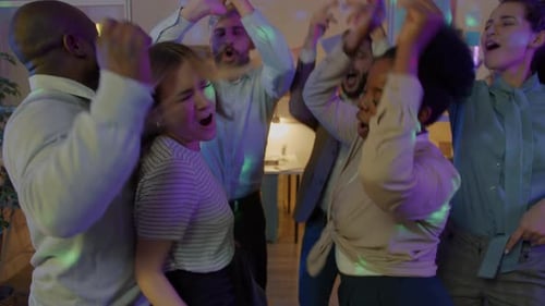 Câmera lenta de funcionários alegres, homens e mulheres, dançando ao som de música em uma festa Corporativo à noite