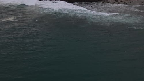 Ocean Waves Crashing on Rocky Shoreline, Aerial View