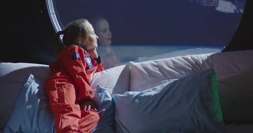 Fille regardant par la fenêtre du vaisseau spatial
