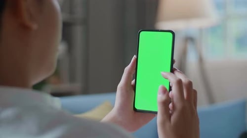 Close Up Of A Man Touching Smartphone With Green Screen In The Living Room