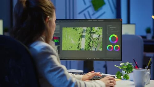 Woman Edits Aerial Footage at Computer Late