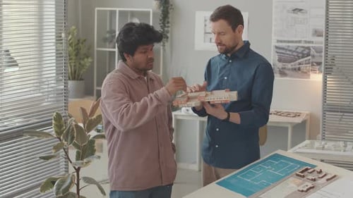 Multiethnic Architects Discussing House Mockup in Office