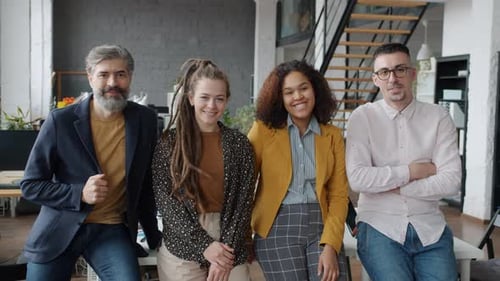 Portrait of Businesspeople Mature and Young Smiling Looking at Camera in Open Space Office