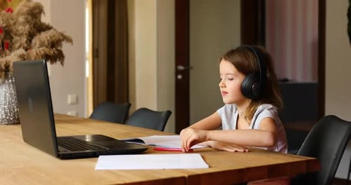 Girl Learning with Laptop at Table Indoors