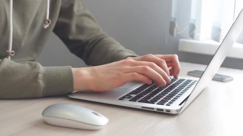 Un hombre de cerca está trabajando en una computadora portátil en casa