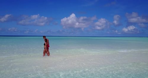 Young couple in love dating on vacation enjoy luxury on beach on clean white sand background