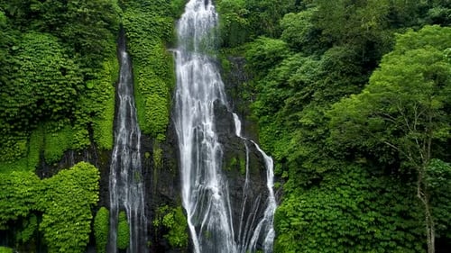 Lush Tropical Waterfall Cascading Through Greenery
