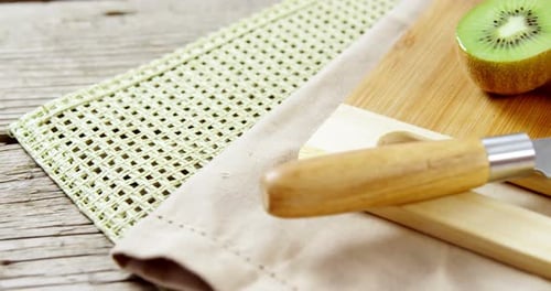 Kiwi and knife on chopping board