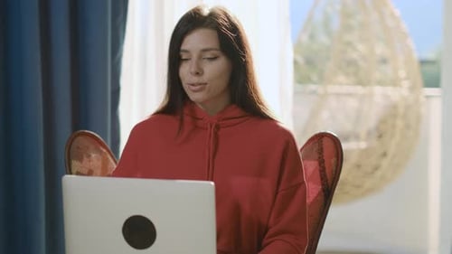 Woman Video Conferencing at Home on Laptop