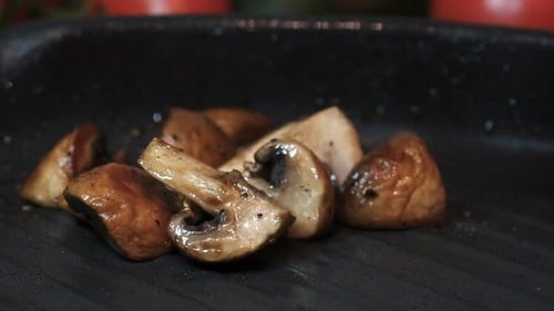 Mushrooms Cooking on a Black Grill