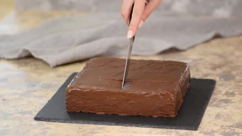 Slicing Rich Chocolate Cake on Slate Board