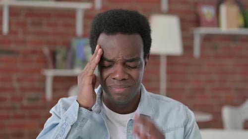 Adult Male Massaging Temples and Looking Sick