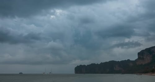 Zeitraffer der Regenwolken über Strand- und Meereslandschaft mit Booten. Tropischer Sturm im Meer.