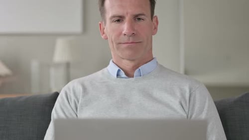 Man Using Laptop While Sitting on Couch