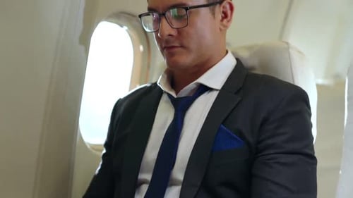 Man in Suit Working on Laptop on Airplane