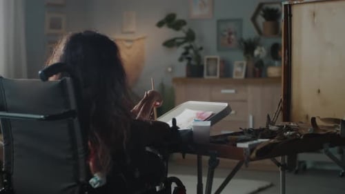Woman in Wheelchair Painting in Home Studio
