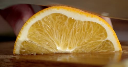The Hand of a Man with a Knife Cut Off the Orange Slices.