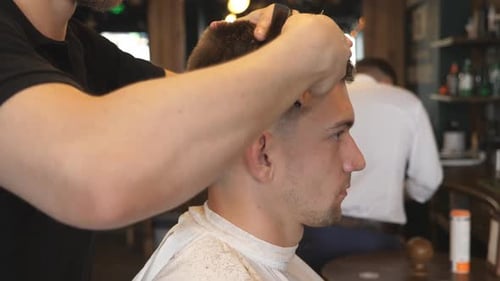 Young Man Getting Haircut at Barbershop