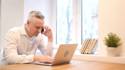 Telefongespräch von Männern aus dem Mittelalter bei der Arbeit am Laptop