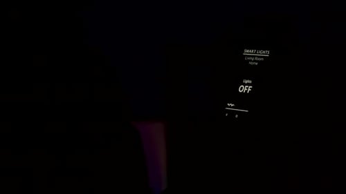 Man Holding a Smartphone with Voice Activation Smart Light App To Turn on the Lights in the House