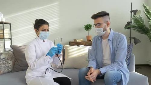 Doctor Checking Patient's Pulse with Stethoscope Indoors