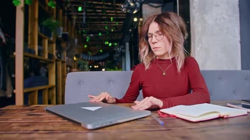 Sad Tired Young Woman Works with Computer at the Table