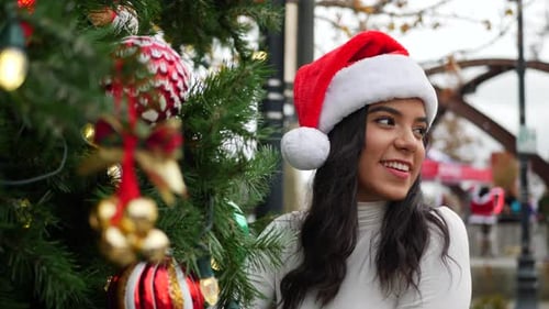 Festive Young Woman Next to Christmas Tree in City