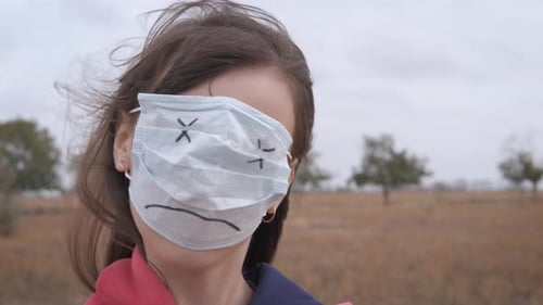 Brunette Girl with Sad Mask Standing in Field