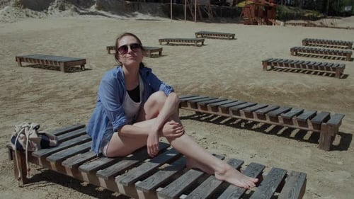 Woman on Vacation Resting on the Beach Lying on a Sun Lounger