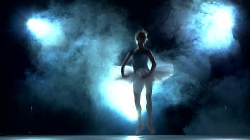 Graceful Ballerina Dances Under Blue Lights and Smoke