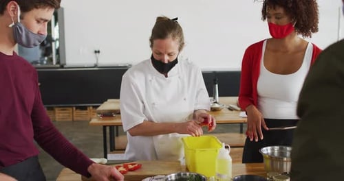 Chef cuts pepper in bright cooking class