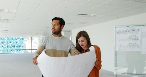 Business people discussing over blueprint in a modern office