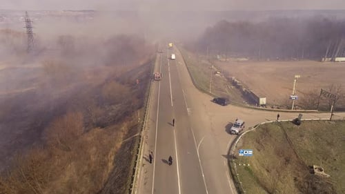 Aerial View of Wildfire Alongside Road with Firefighters