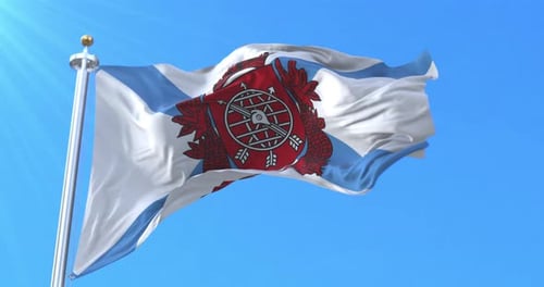 Detailed Waving Flag with Emblem Against Bright Blue Sky