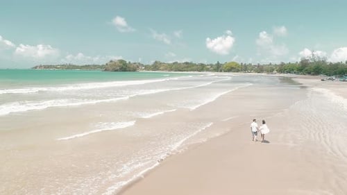 Couple Walking On A Sandy Beach