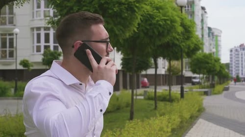 Man Talking on Phone in Urban City Park