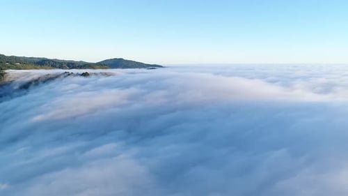 Aerial View Over Vast White Clouds and Green Land