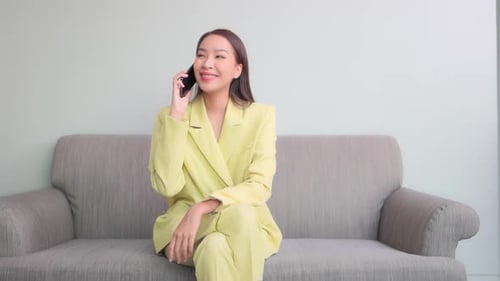 Woman Talking on Phone While Sitting on Sofa