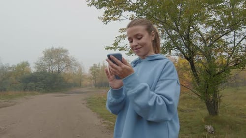 Cheerful Woman Using Mobile Phone Outdoors