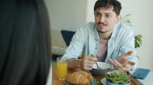 Young Man Chatting Over Breakfast with Friend
