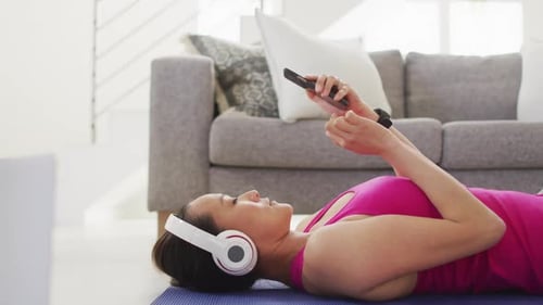 Woman Using Smartphone While Lying on Yoga Mat