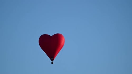 Red Heart Balloon Floats in Blue Sky
