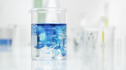 Blue Substance Diffusing in Beaker in Laboratory Setting