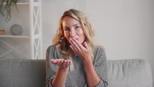 Woman Sending Air Kisses on Sofa