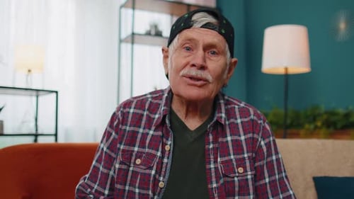Senior Man Waving and Talking on Camera at Home