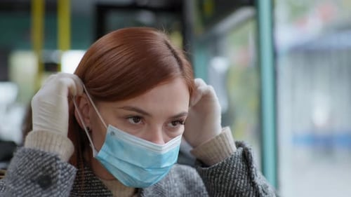 Woman Puts on Mask While Riding Public Bus