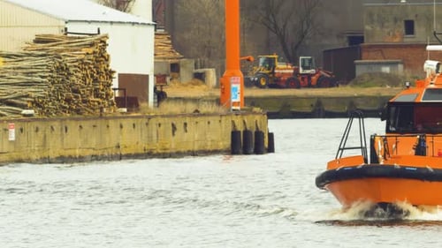Orange port pilot ship leaving Port of Liepaja (Latvia), overcast spring day, medium shot