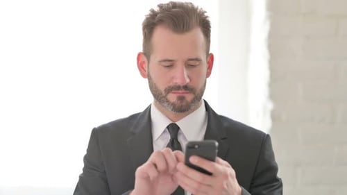 Man in Suit Using Smartphone