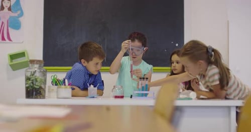 Elementary School Science Classroom Enthusiastic Teacher Explains Chemistry to Diverse Group of