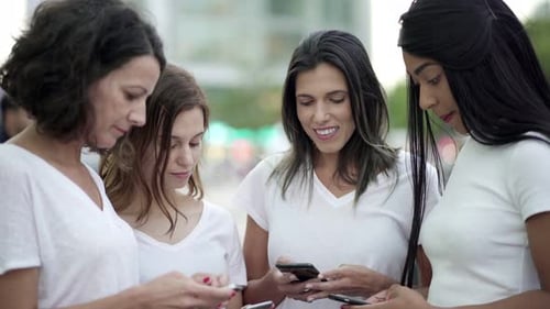 Cheerful Women Standing in Circle and Using Smartphones